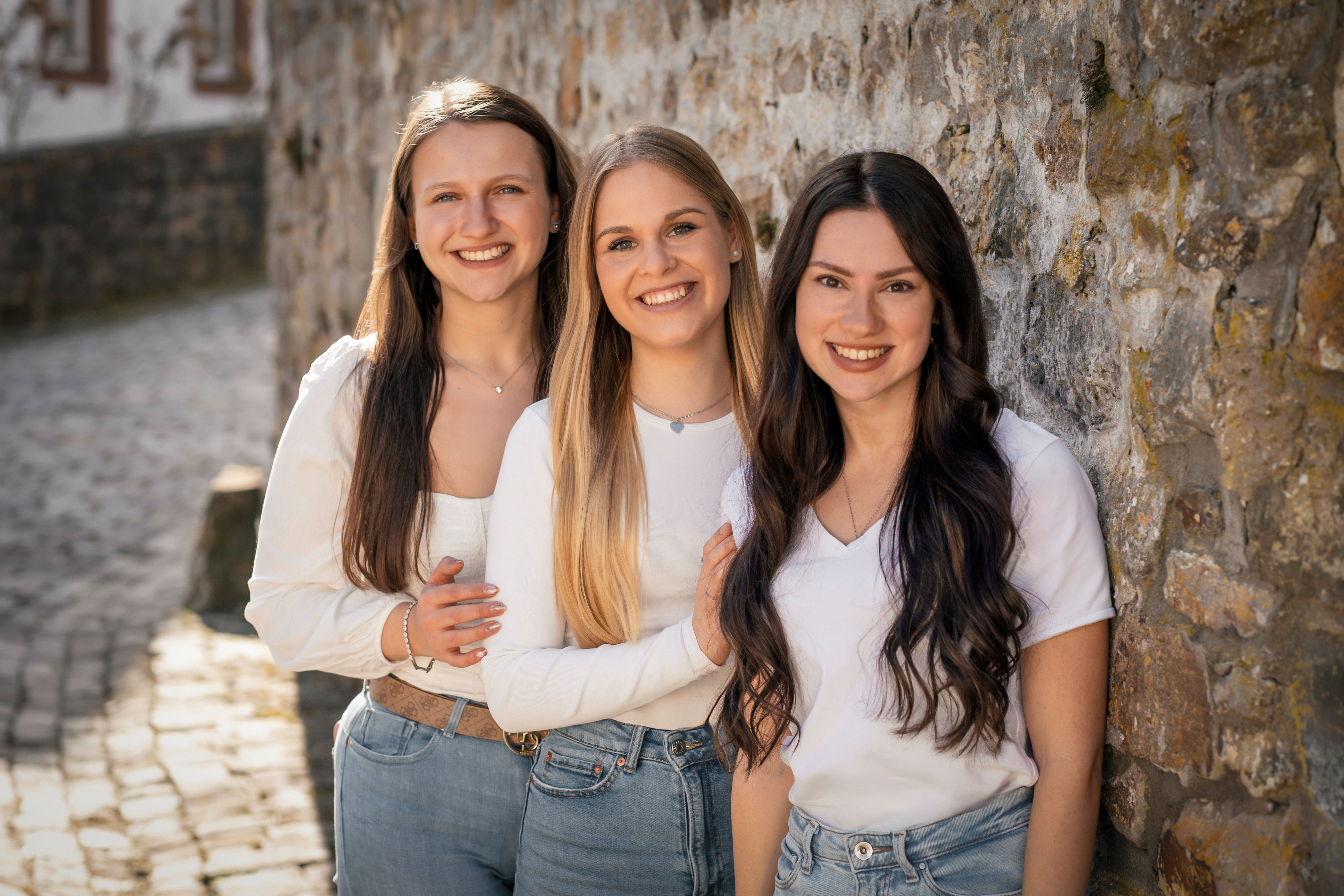 Drei Frauen vor Steinmauer