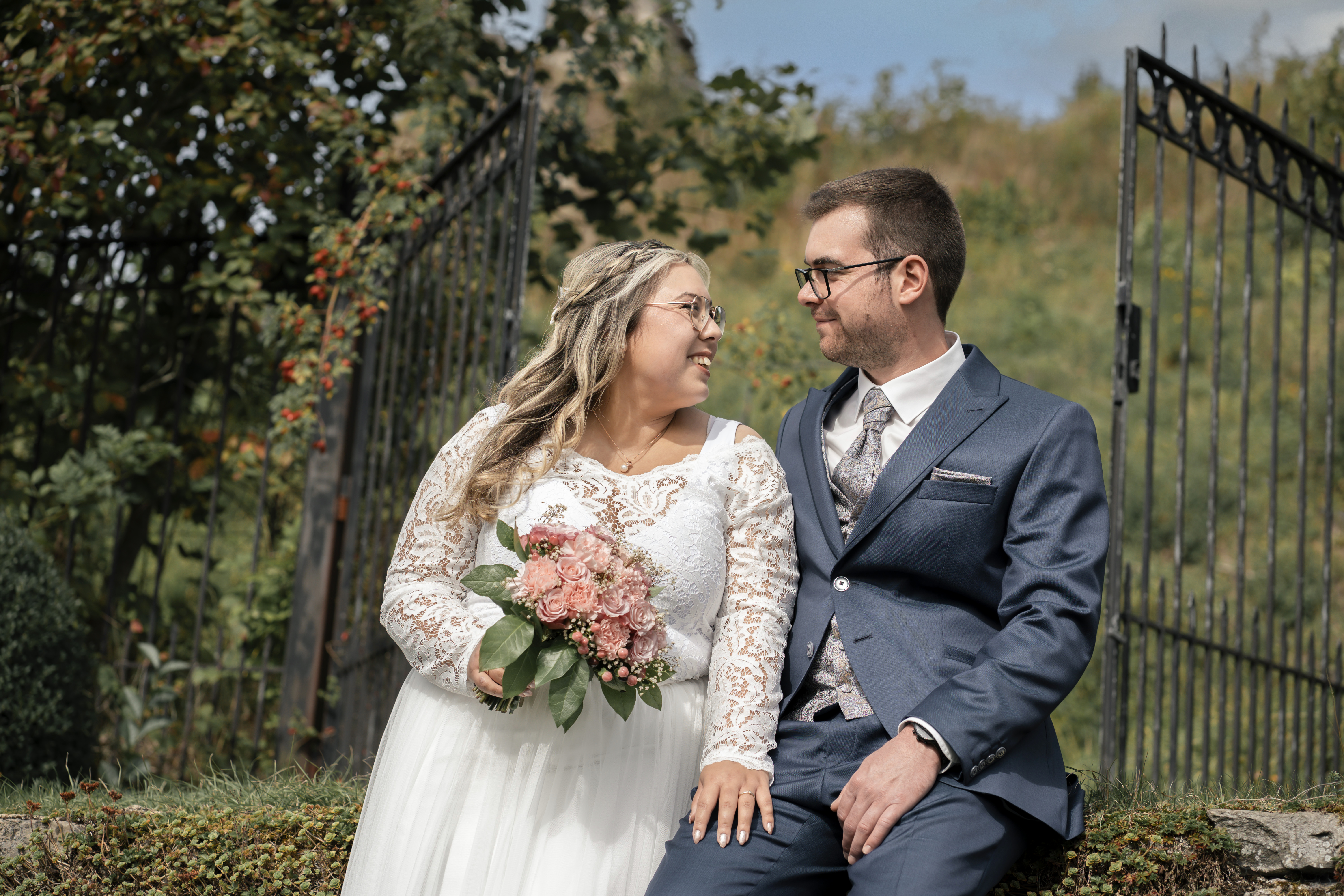 Hochzeit – Brautpaar sitzend, lächelnd